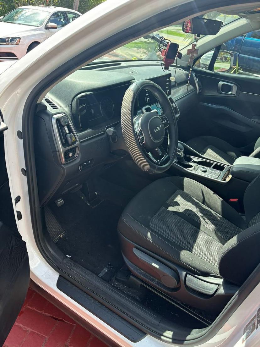 Kia Sorento front cabin with a dirty floor and a cluttered dashboard before cleaning