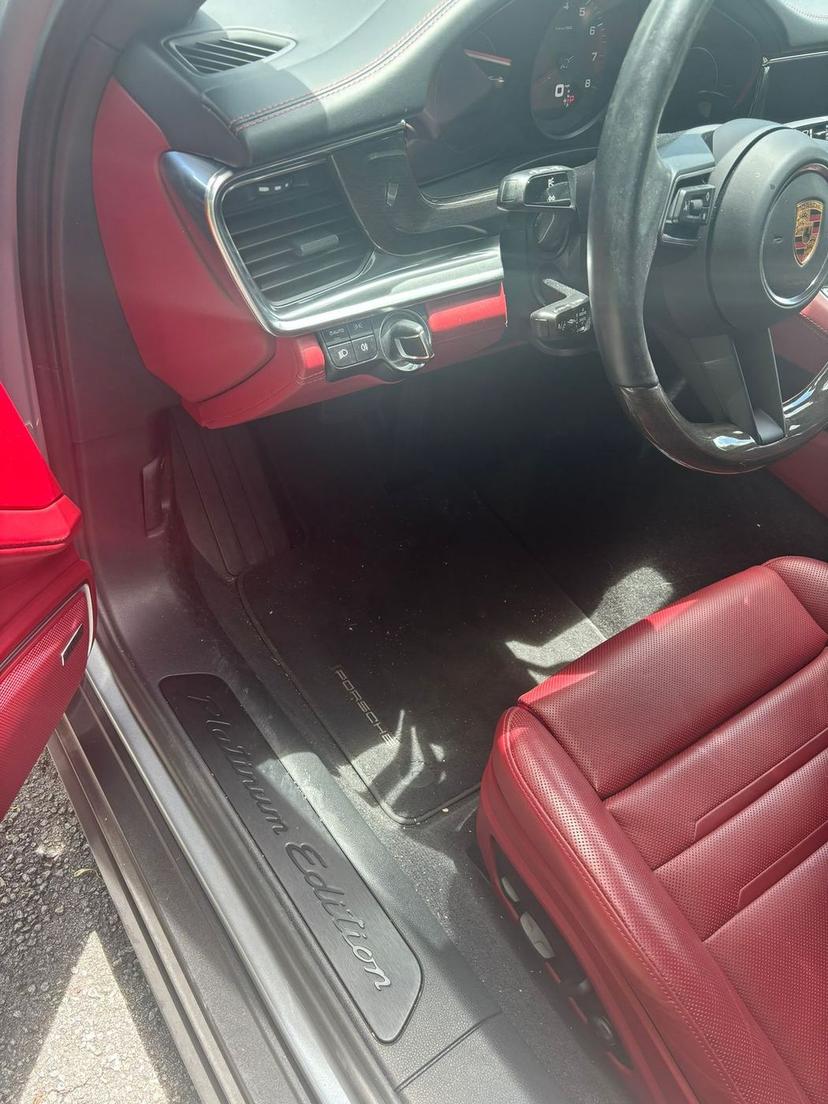 Porsche Panamera interior with a dusty dashboard and dirty carpet before cleaning