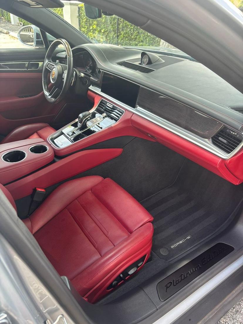 Spotless Porsche Panamera interior with red leather seats and a clean black carpet